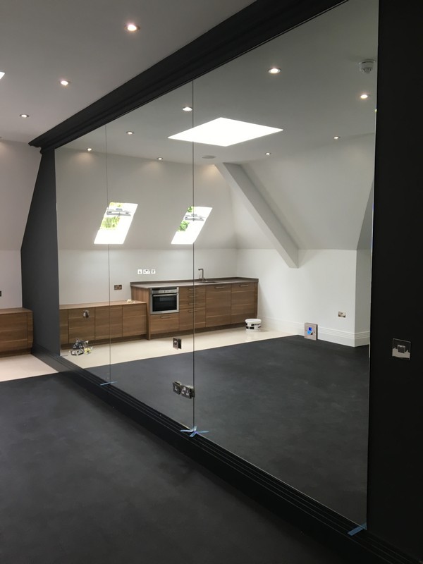 Frameless glass partition in loft conversion by Winchmore Hill glaziers