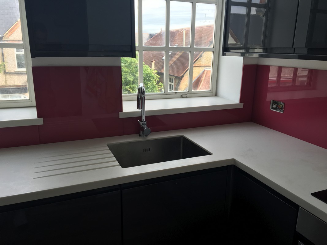 Deep plum coloured glass splashback in modern Winchmore Hill kitchen